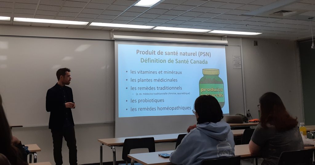 Olivier Bernard en présentation devant un groupe, avec une présentation sur tableau blanc