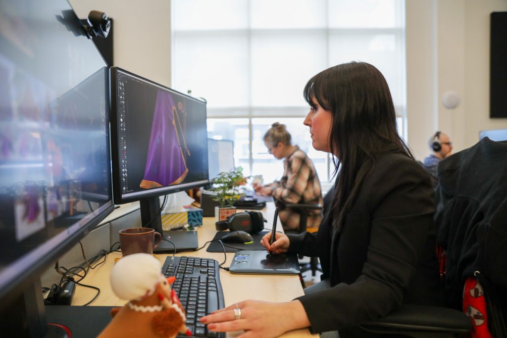 Artiste 3D crée un objet. Elle travaille à la tablette graphique.