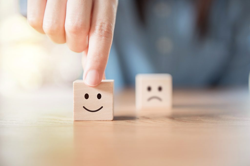 Un cube avec un sourire et un cube avec un visage triste.