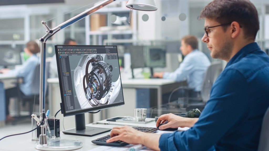 Homme devant un logiciel contenant un dessin 3D.