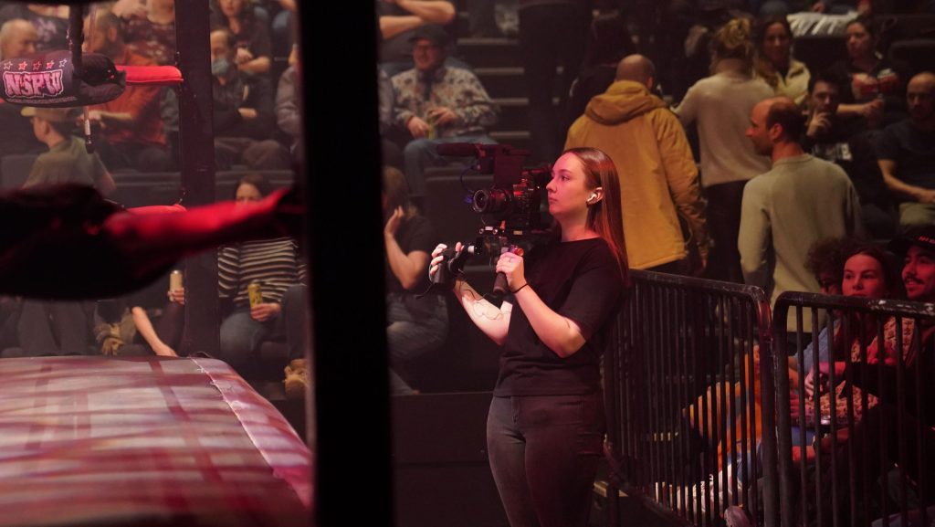 Éloïse derrière la caméra lors d'un tournage d'un match de lutte