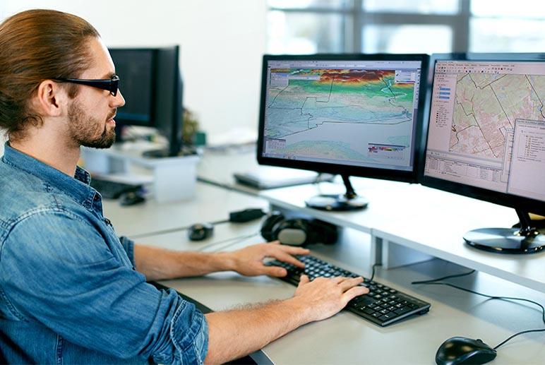 Homme à l'ordinateur qui travail en géomatique