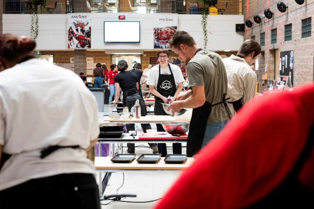 Groupe d'étudiants et d'étudiantes en train de préparer un plat pour la compétition Moi je cuisine !