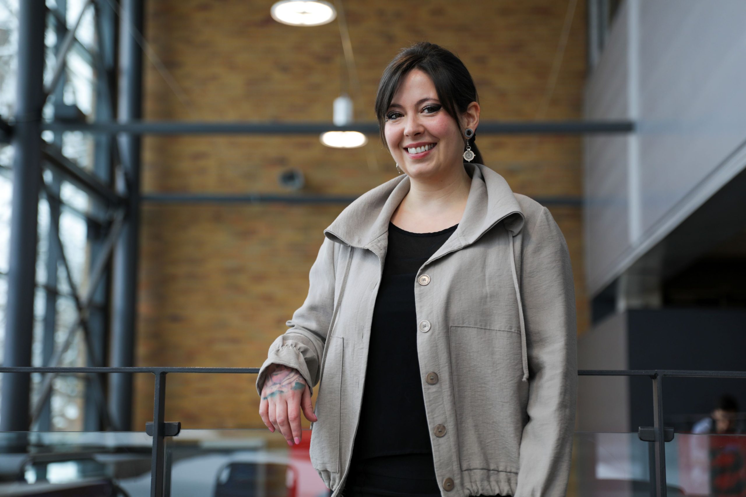 Une employée souriante, debout à la galerie du cégep