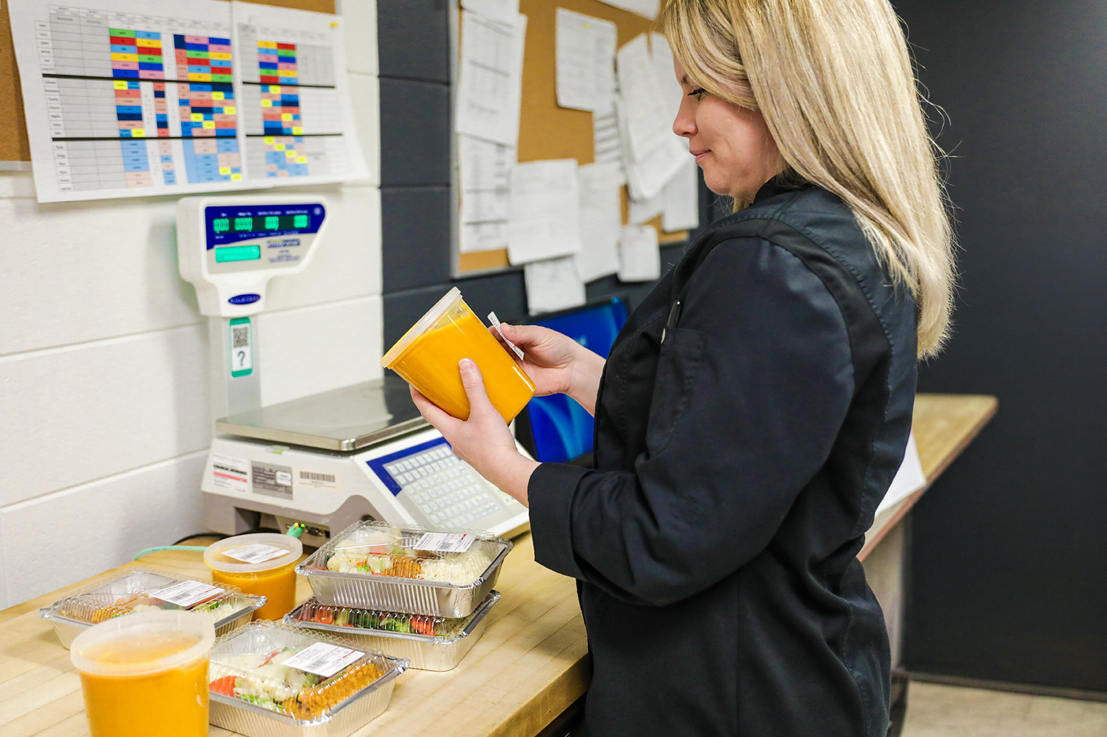 Une enseignante en technique Diététique qui étiquette un contenant de soupe