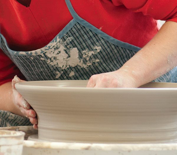 Céramiste qui sculpte un plat.