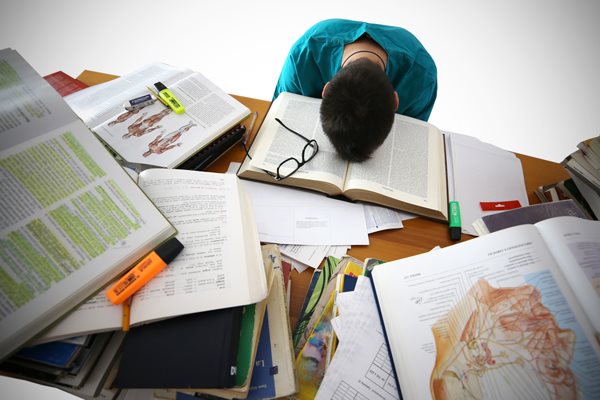 étudiant fatigué tête dans ses livres
