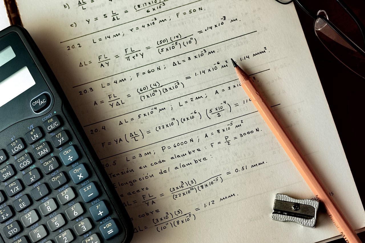 Formule math sur papier avec calculatrice, crayon et aiguisoir