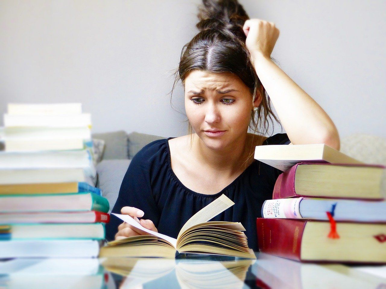 Jeune fille qui lit et est entourée de livres