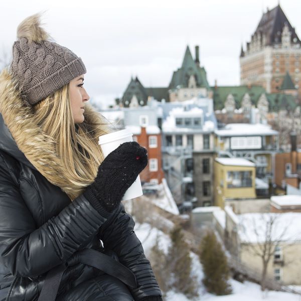 Femme buvant un café devant le Château Frontenac