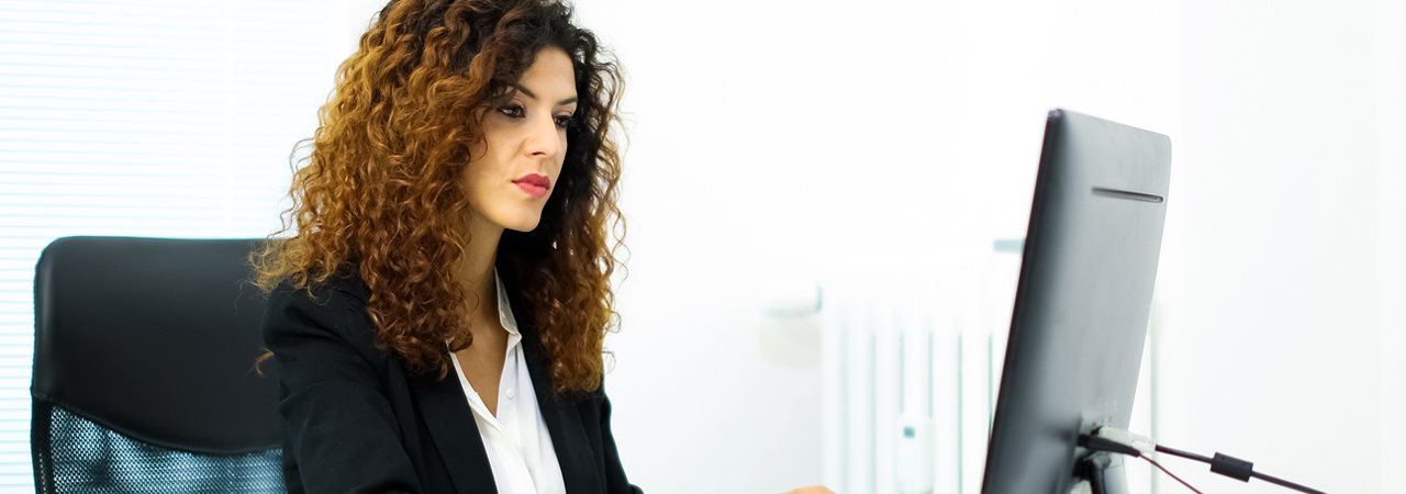 Femme cheveux frisés devant ordi