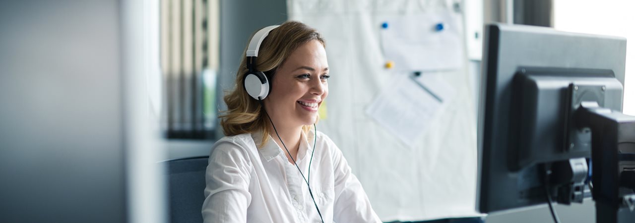 Femme écouteurs devant ordinateur