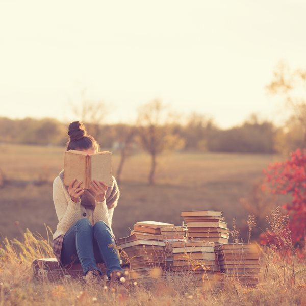 Fille cachée derrière livre