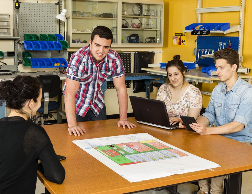 Étudiants en génie industriel autour d'une table et d'un plan