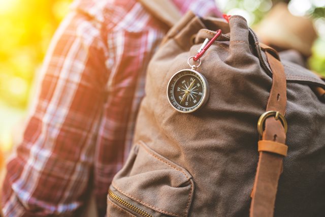 Vue sur dos d'une personne portant un sac à dos et boussole