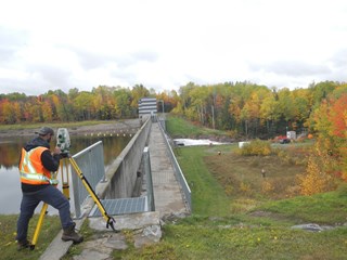 Étudiants en géomatique prise de mesures devant lac paysage d'automne