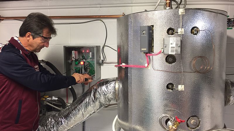 Alain Marineau fait des ajustements sur son système pour chauffer l'eau chaude
