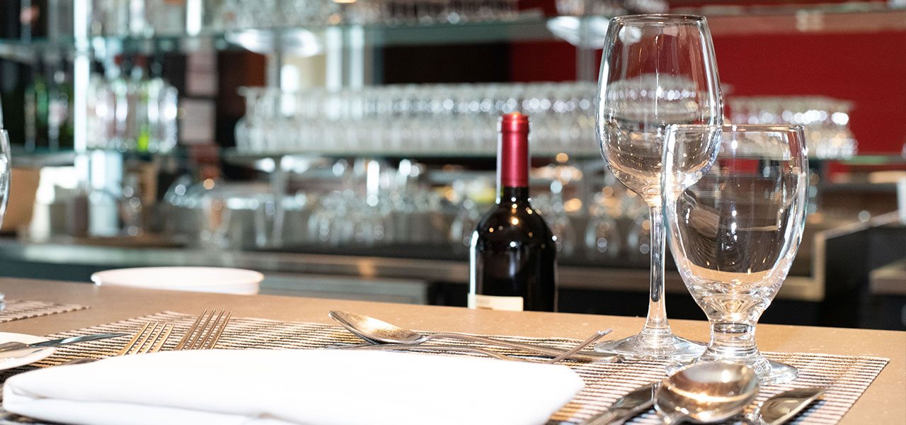 Assiettes, couverts et verres au bar de La grappe d'or, salle à manger pédagogique