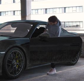 Homme entrant dans une voiture noire