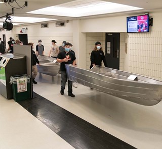 Étudiants en génie mécanique qui transportent les chaloupes dans la piscine