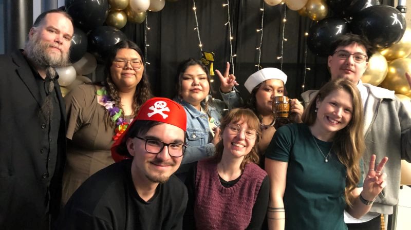 Les étudiants célèbrent et sourient à la caméra.