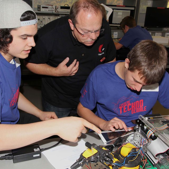 Des étudiants réalisent un projet électronique sous la supervision d'un enseignant