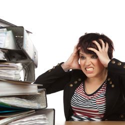 Femme découragée devant pile de livres