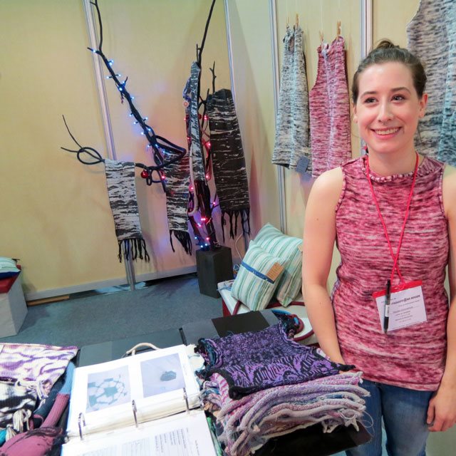devant ses œuvres de construction textile
