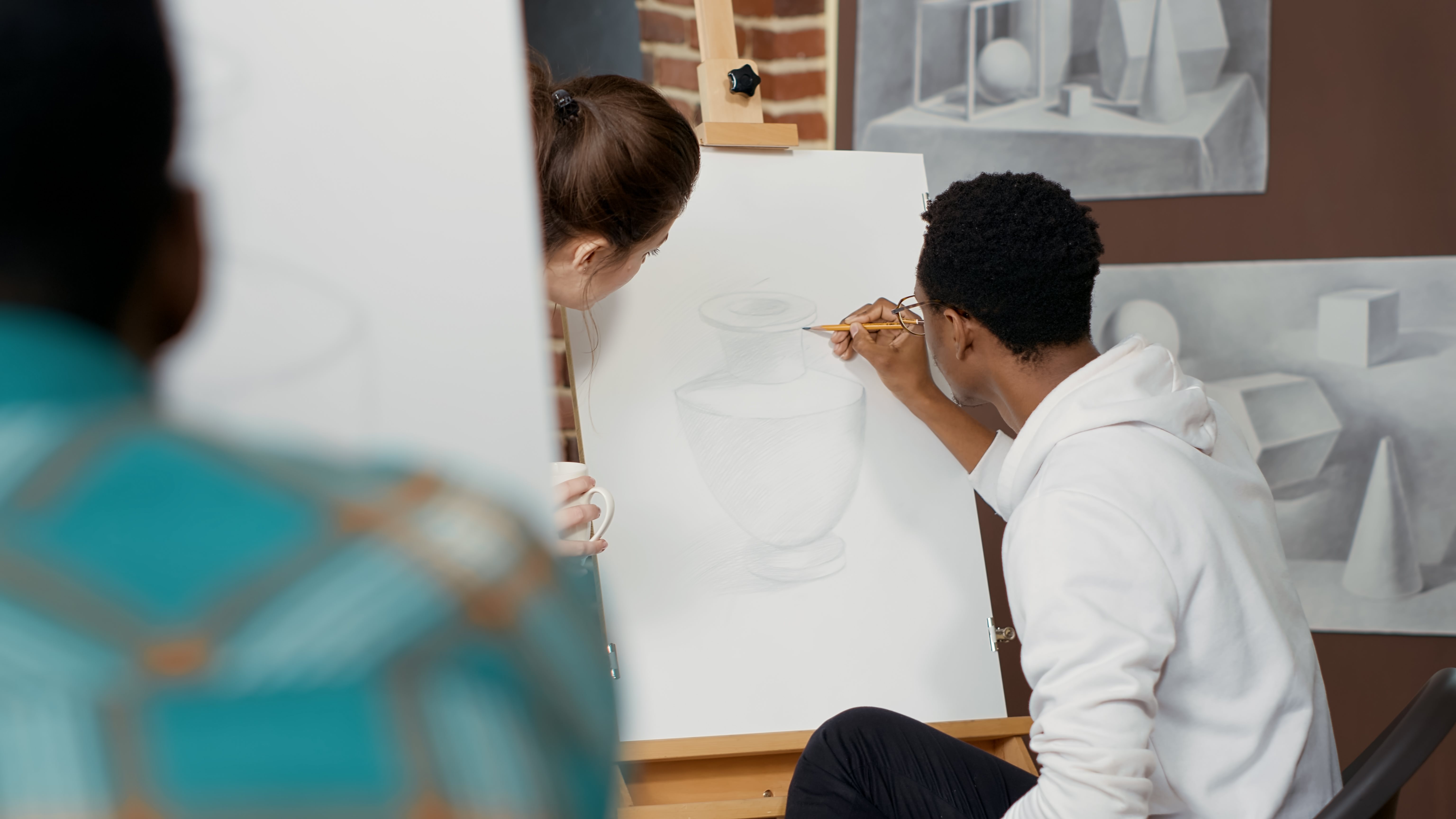 Une personne dessinant au crayon un vase sur une toile 