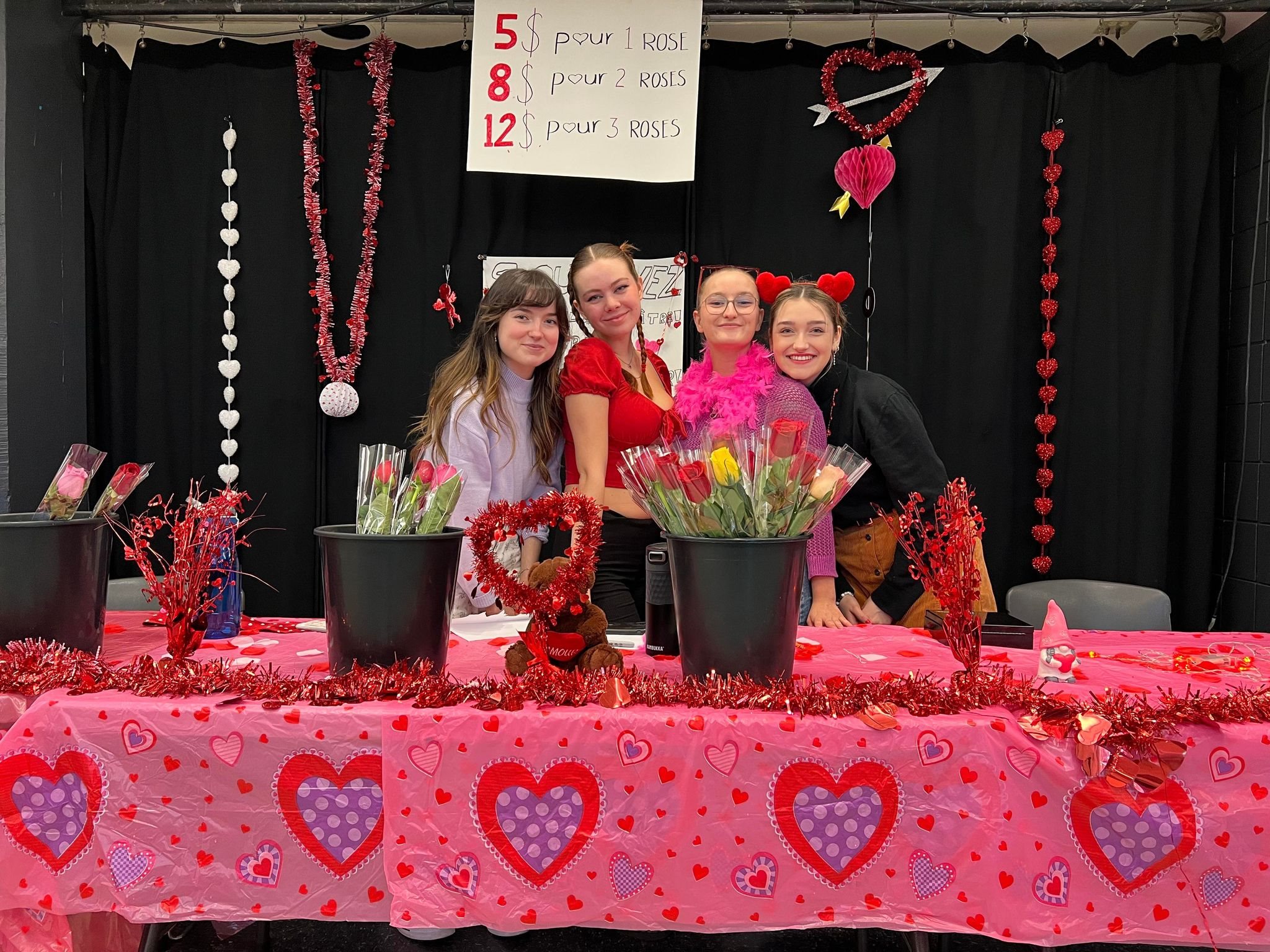 Quatre étudiantes derrère une table de vente de roses pour la St-Valentin