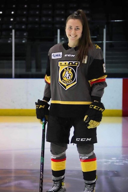 Rosalie Breton, souriante en uniforme sur la glace avec son bâton de hockey