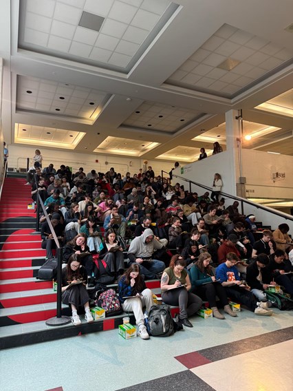 Les étudiants assis dans le grand escalier.
