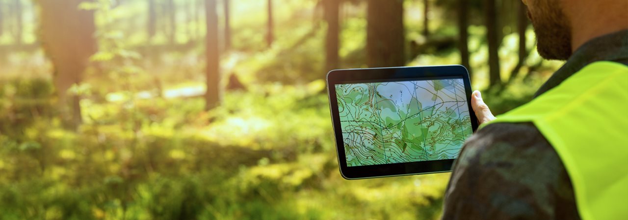 Un homme avec sa tablette recueille des données sur le terrain.