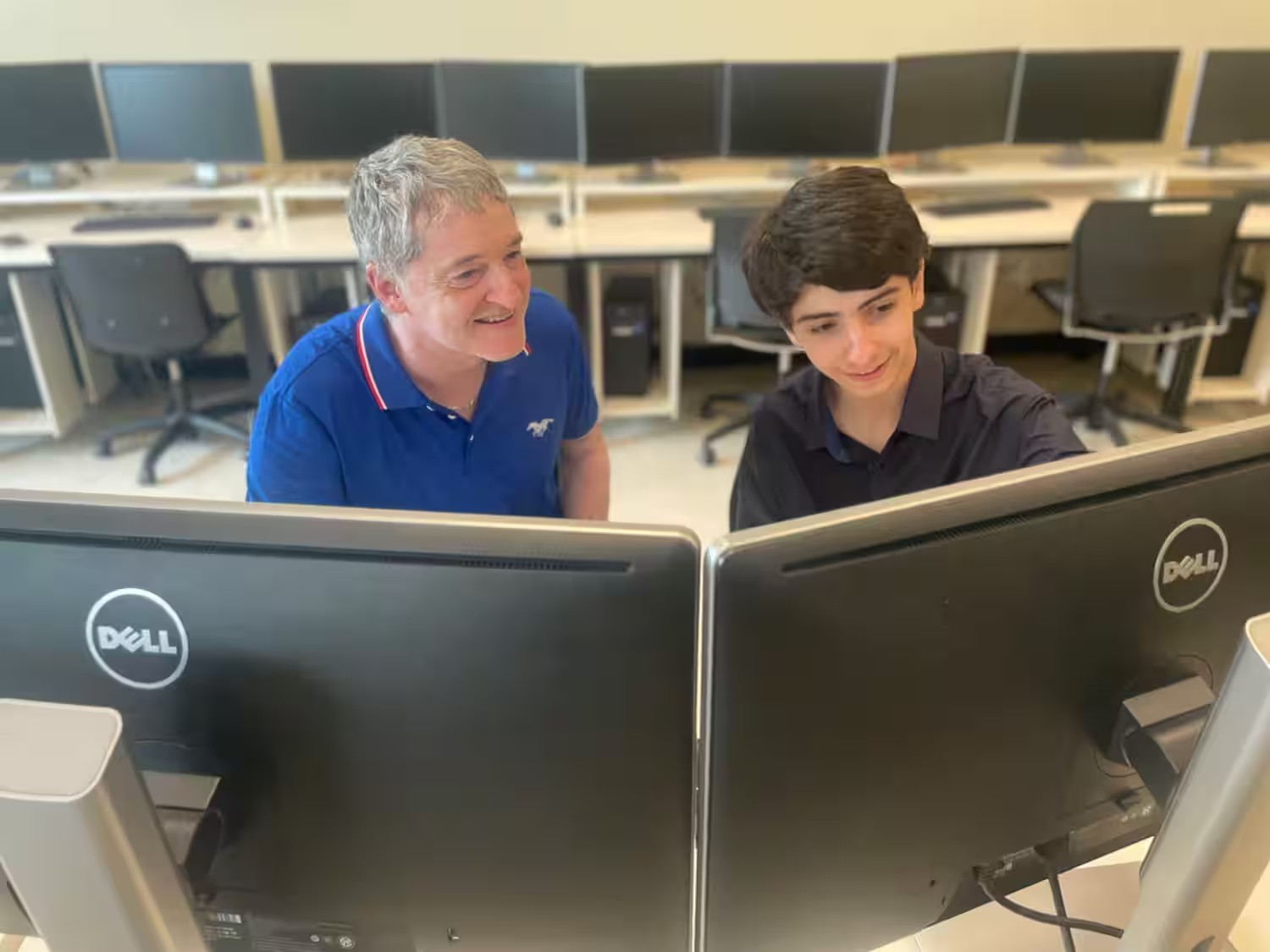 Un père et son fils regarde un écran d'ordinateur.