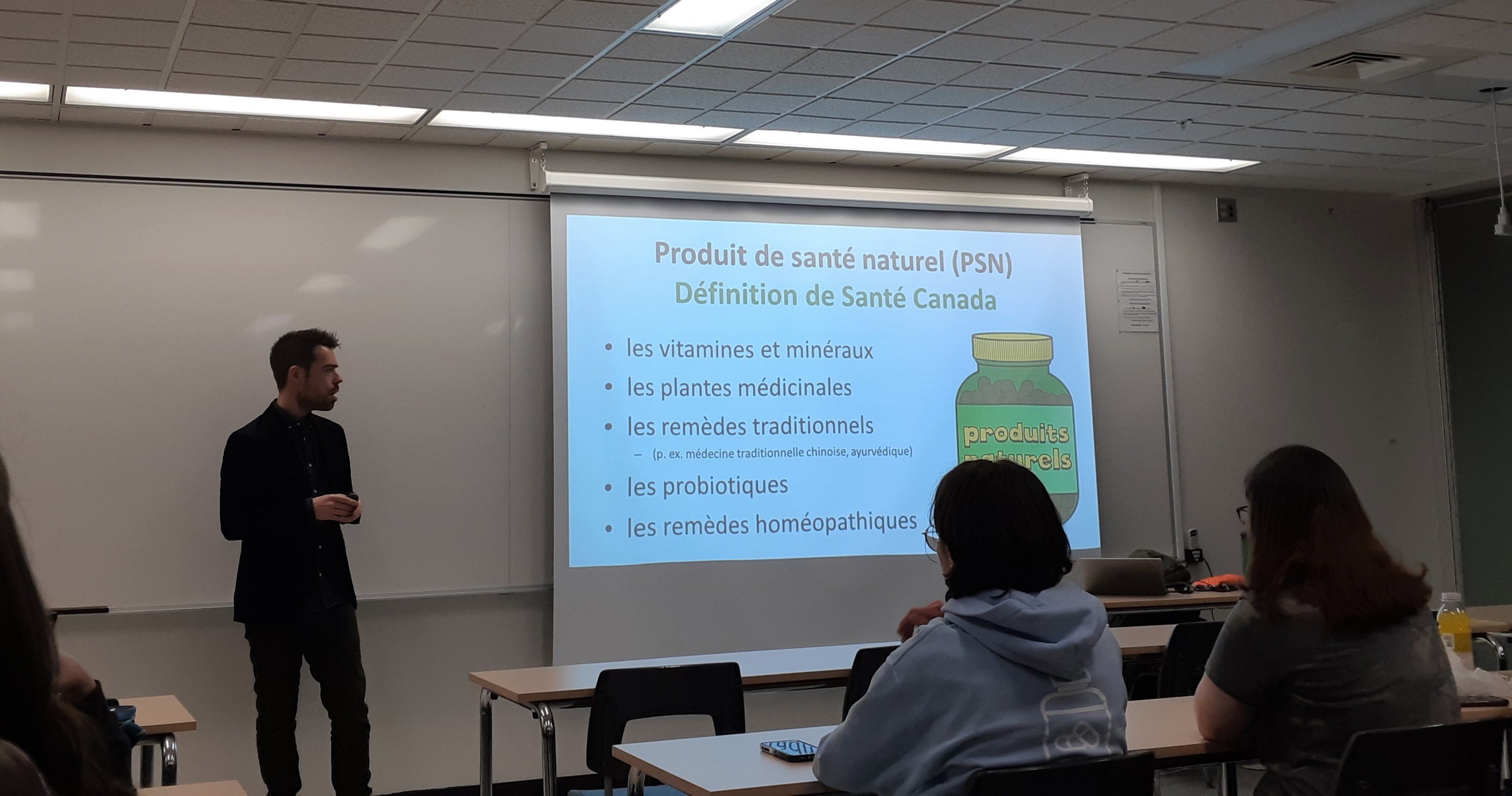 Le pharmacien Olivier Bernard, devant un tableau en pleine présentation devant les étudiants et étudiantes du programme de pharmacie