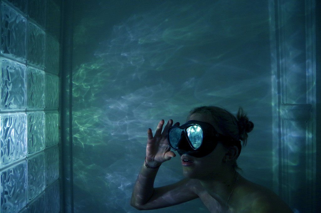 photographie de Delphine Larocque initulée Plongée en lumière 1 où l'on peut voir une plongeuse sous l'eau  avec des ombres et des lumières