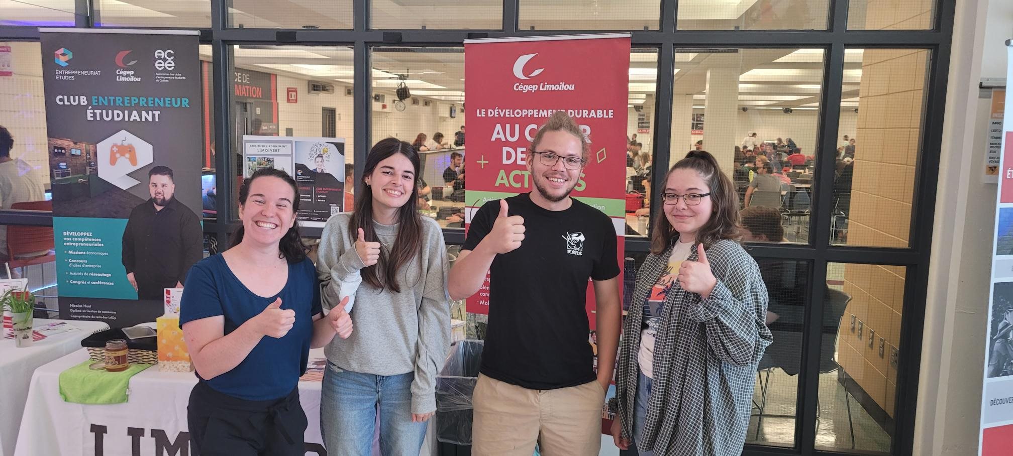 Étudiants membres du Club entrepreneur étudiant devant un kiosque, souriants