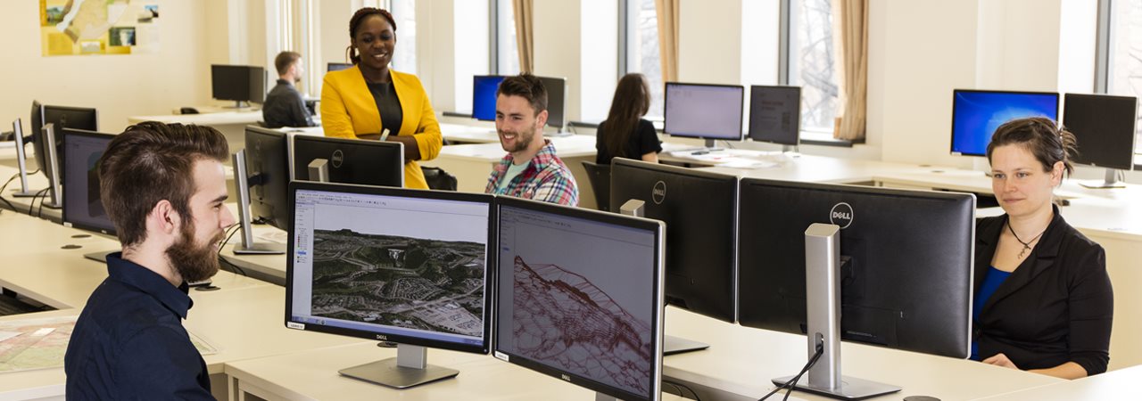 Futurs géomaticiens au travail devant ordinateur dans un laboratoire de cartographie