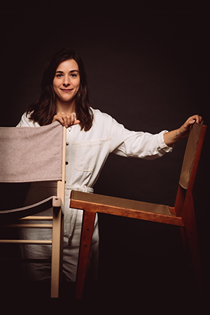 Catherine Chevalier, ébéniste, pose avec deux chaises en bois