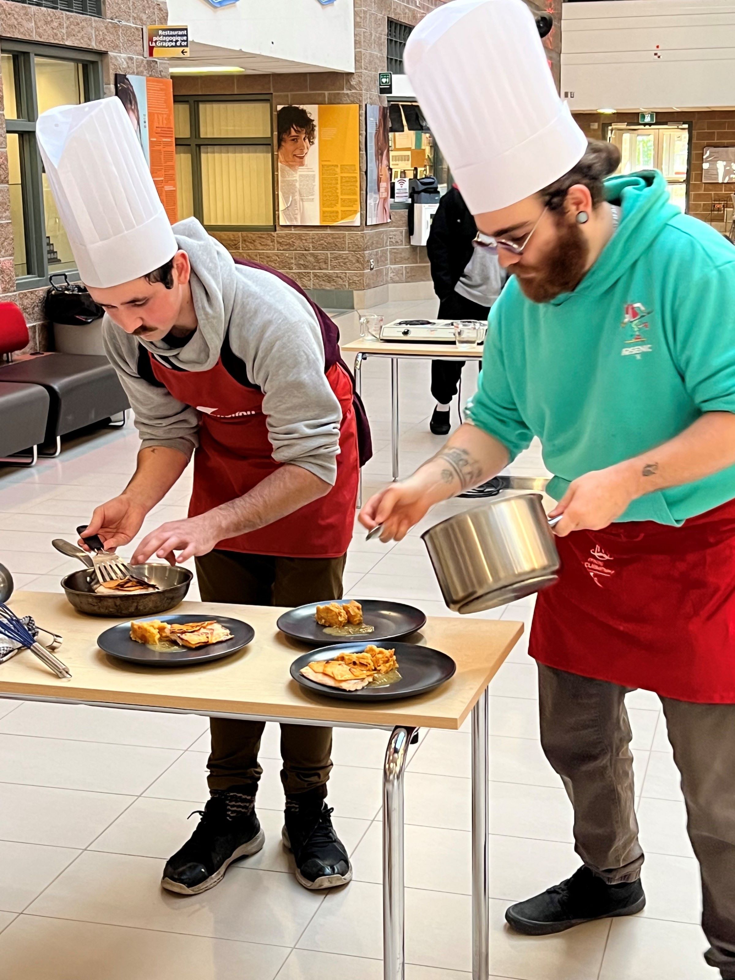 Deux étudiants préparant un plat lors du concours Moi je cuisine
